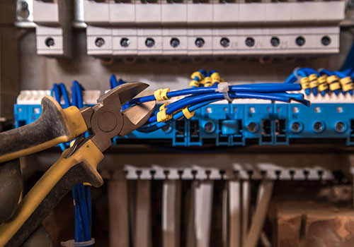 the Assembly of the electrical panel, electrician job, a robot with wires and circuit breakers, tools
